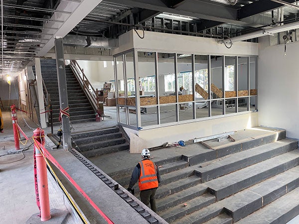 wide concrete stairs next to regular concrete steps in front of interior windows