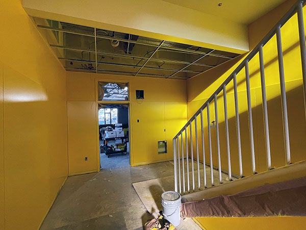 a yellow hallway with a stairway