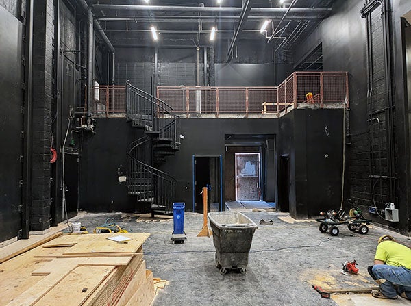 construction area in a black room with a sprial staircase