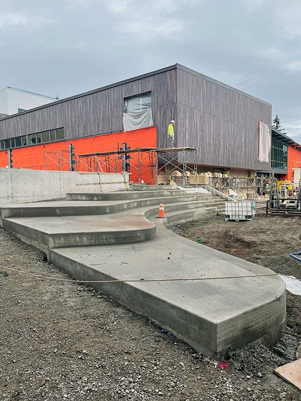 concrete steps with curved faces lead to a building under construction