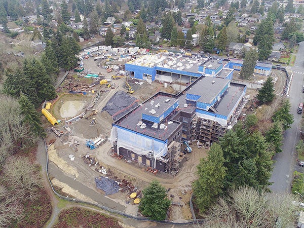 aerial showning a large L shaped building and construction site