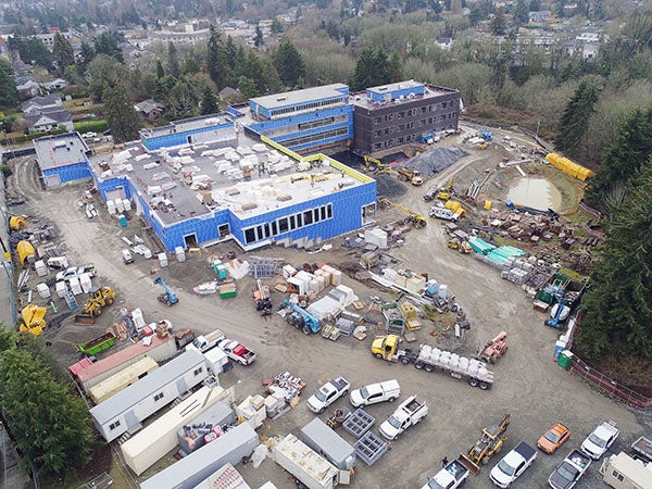 aerial showning a large L shaped building and construction site