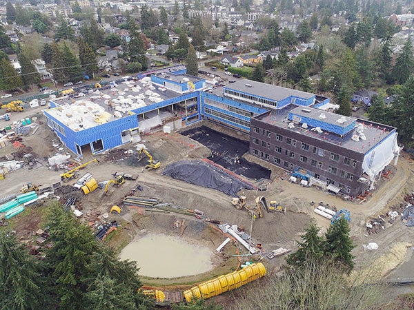 aerial showning a large L shaped building and construction site