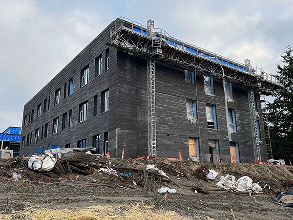 a three story building with dark colored masonry and construction materials