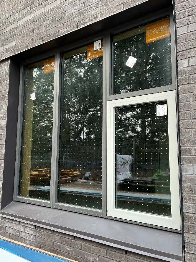 closeup of a window with glass that has dots on it. brick veneer surrounds the window