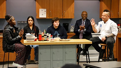 Students and Superintendent Jones join Chef Tila at a table