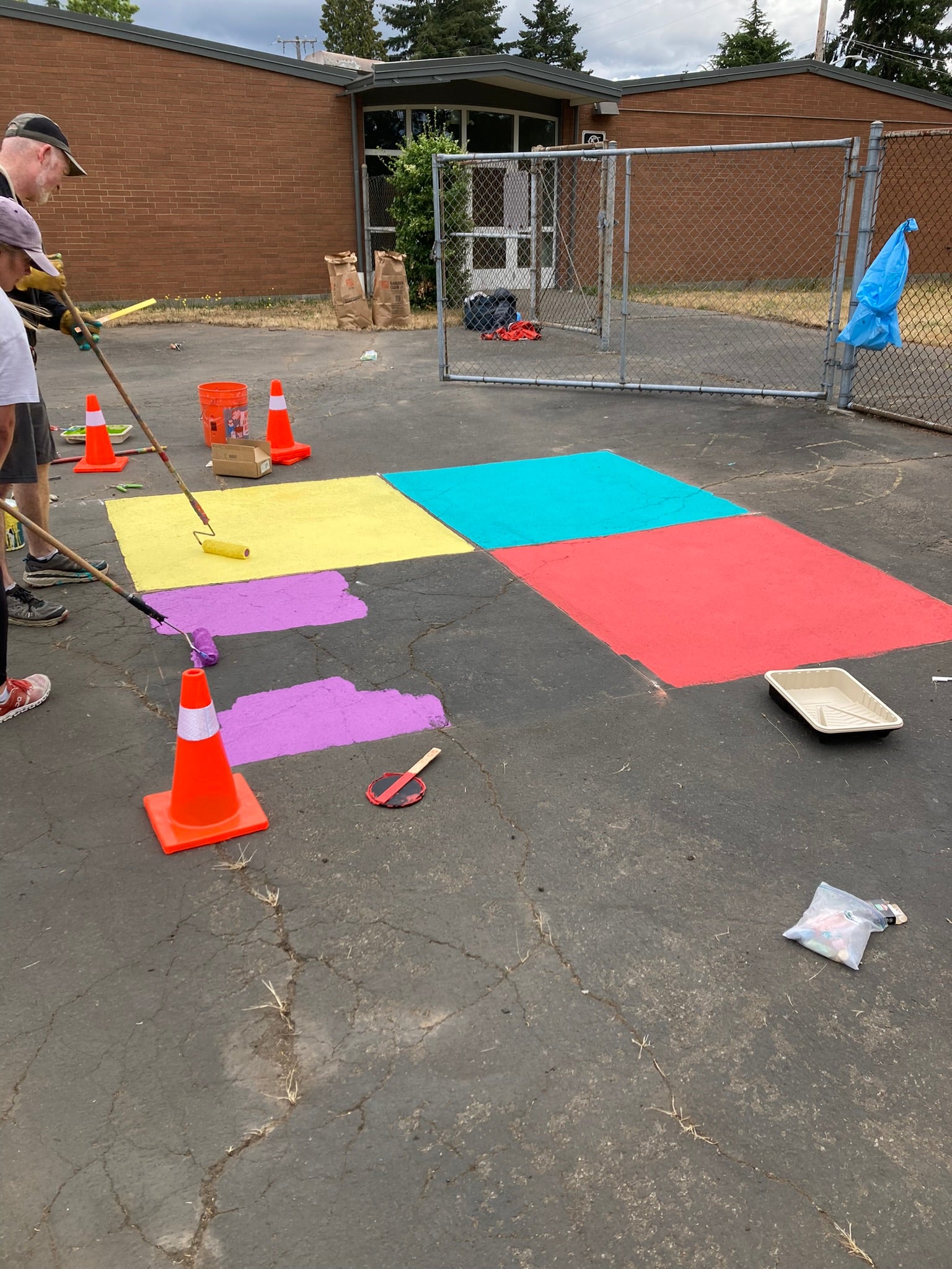 Volunteers painting four square court