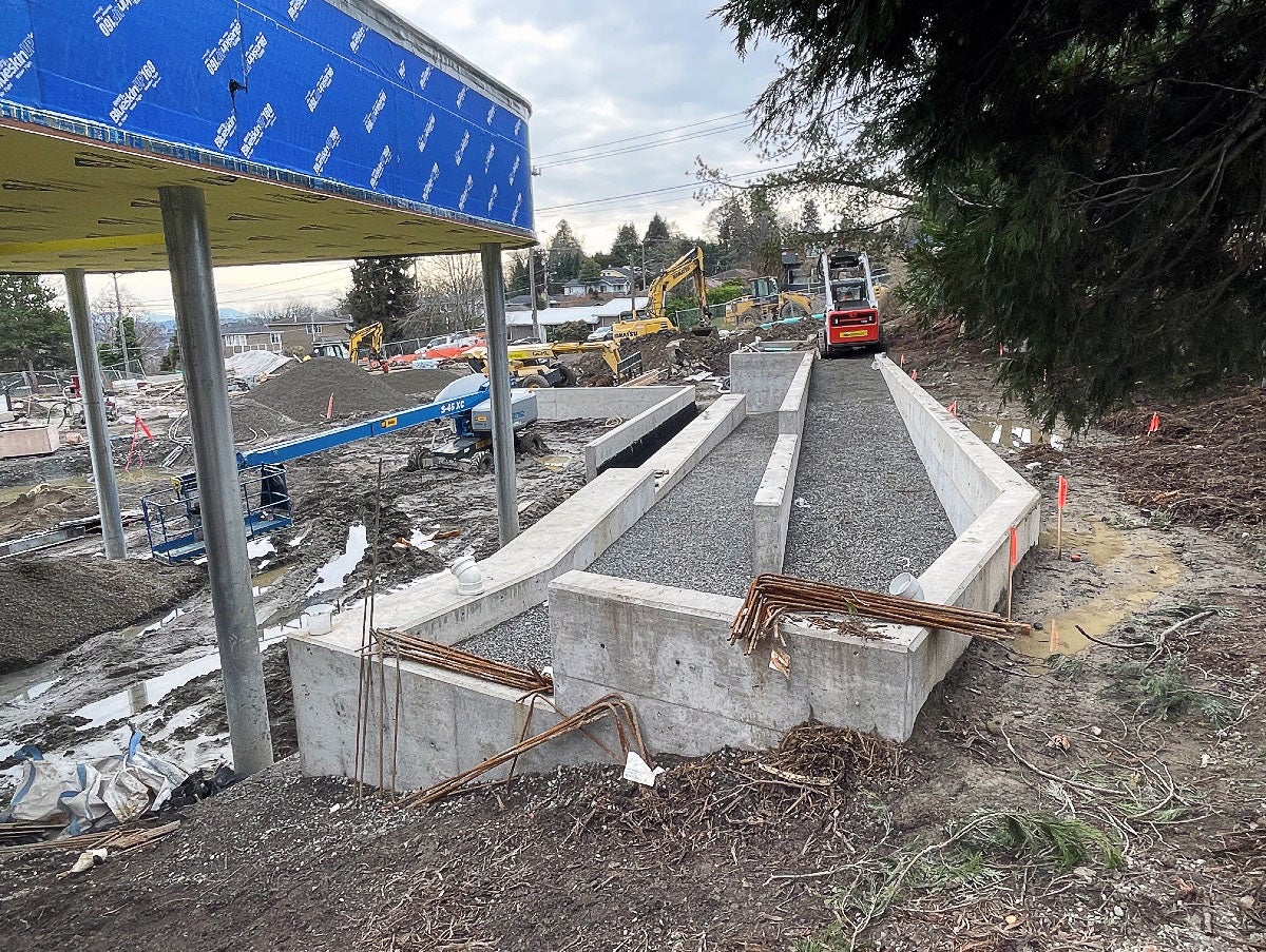 concrete walls are in place in a hillside with gravel between them, creating a ramp