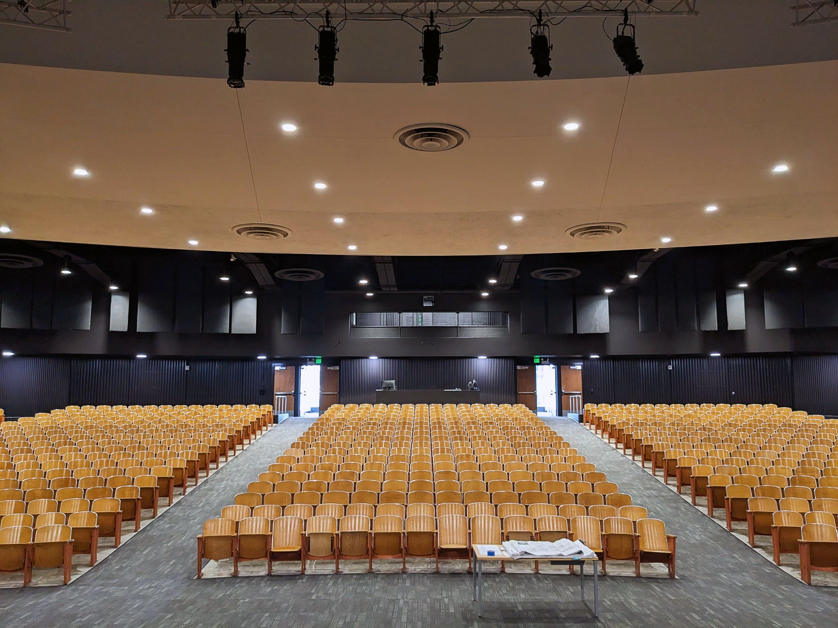 a large room with theatre style seating in three sections and a carpeted floor