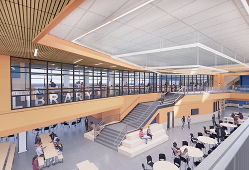 large common area with dining tables and stairs; a room with glass windows looking out toward below says LIBRARY