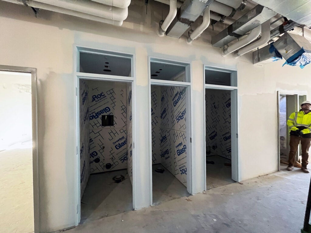 3 closets with walls around them that are partly painted