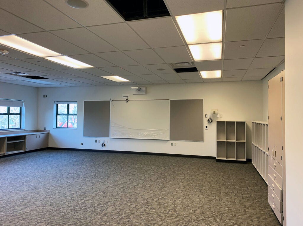 a classroom with no furniture but with cabinets and a white board