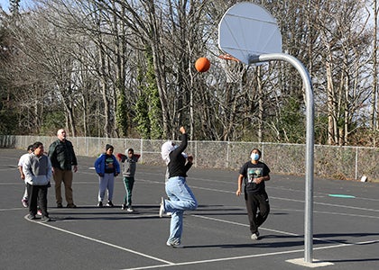 A group of students plays basketball on a playground