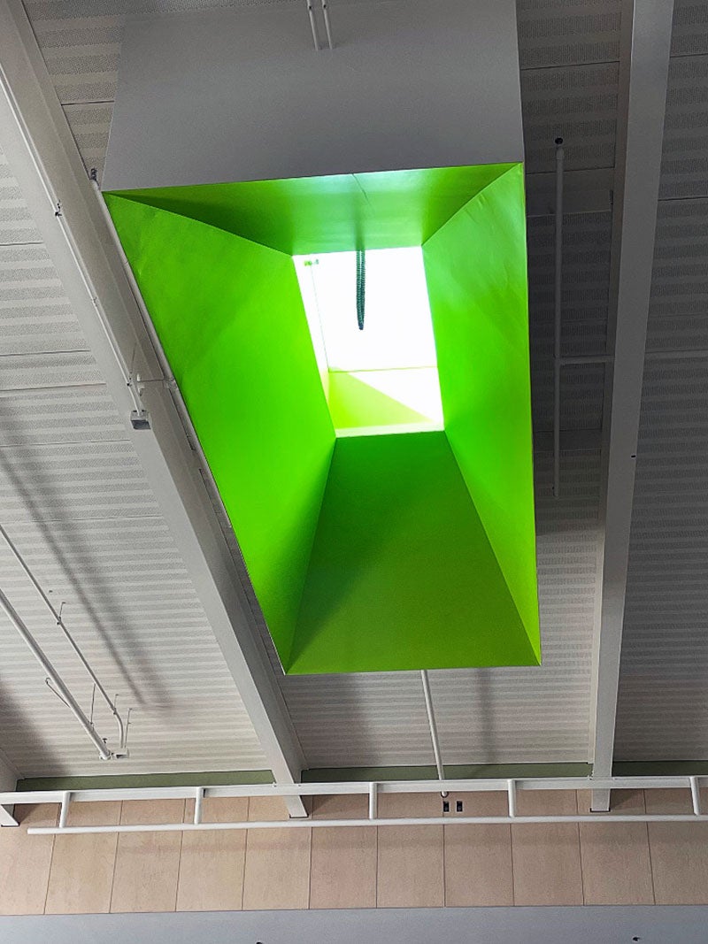 looking up to a high ceiling that has a skylight framed in bright green