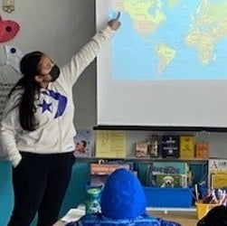 A student teacher points to a map