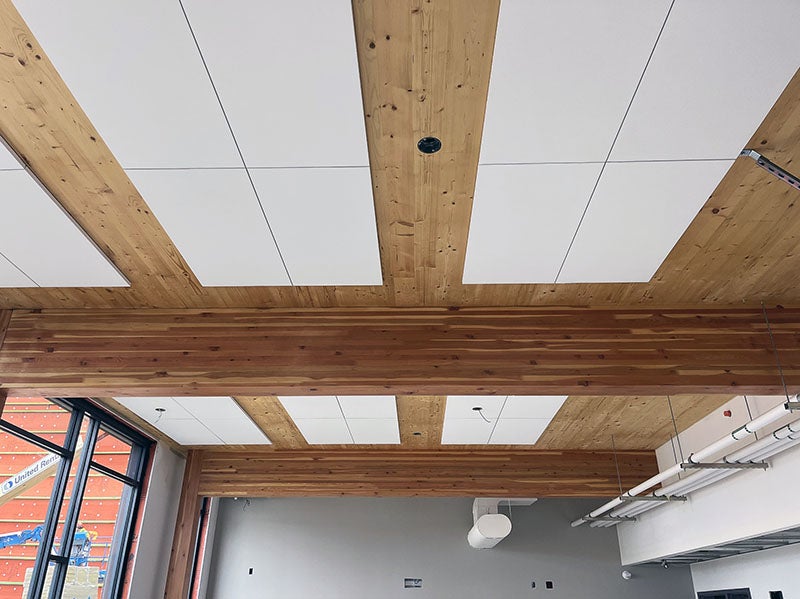 a ceiling with wood between tiles and large wood beams