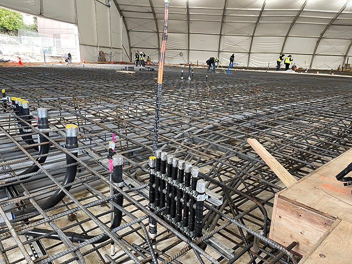 a vast spread of a rebar cage with workers adding more