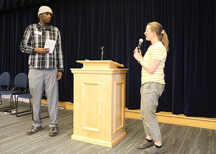 A teacher speaks to the audience about a student at the award ceremony