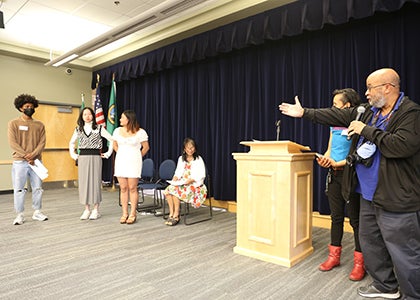 A teacher presents three students during an award ceremony