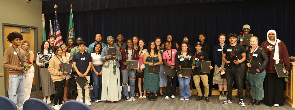 A large group of students gather for a photo in the auditorium