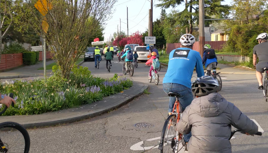 Students and adults biking in a group outside