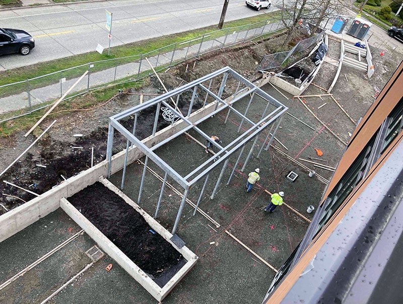 a metal frame is being installed on a concrete pad