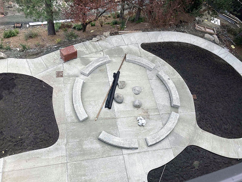 four pathways lead to a central circle with curved seating and boulders in the center
