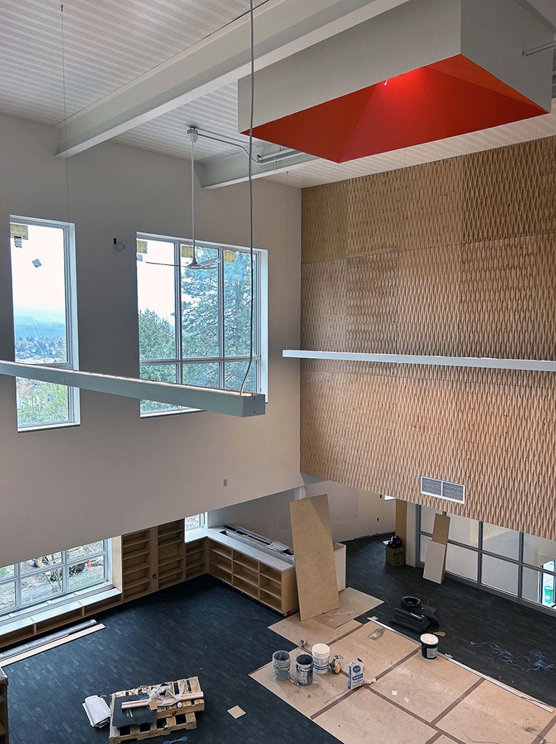 Patterned wood is on the upper wall of a two-story atrium