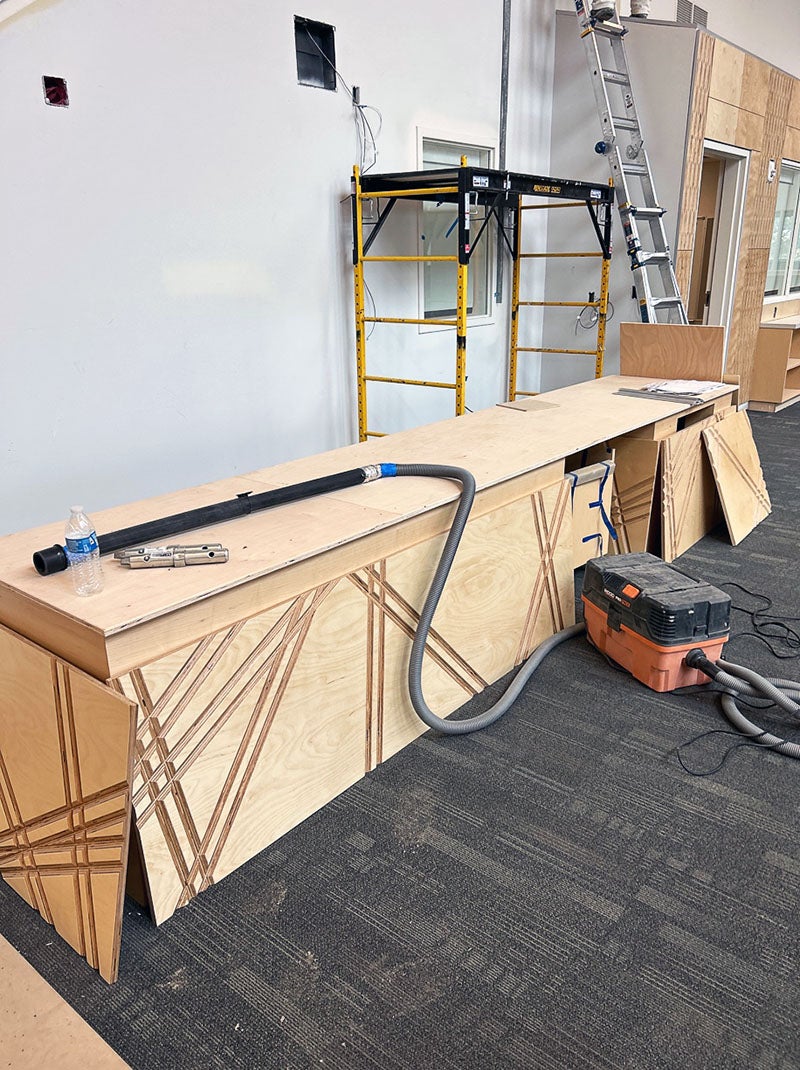 a table has textured wooden panels being installed on the side