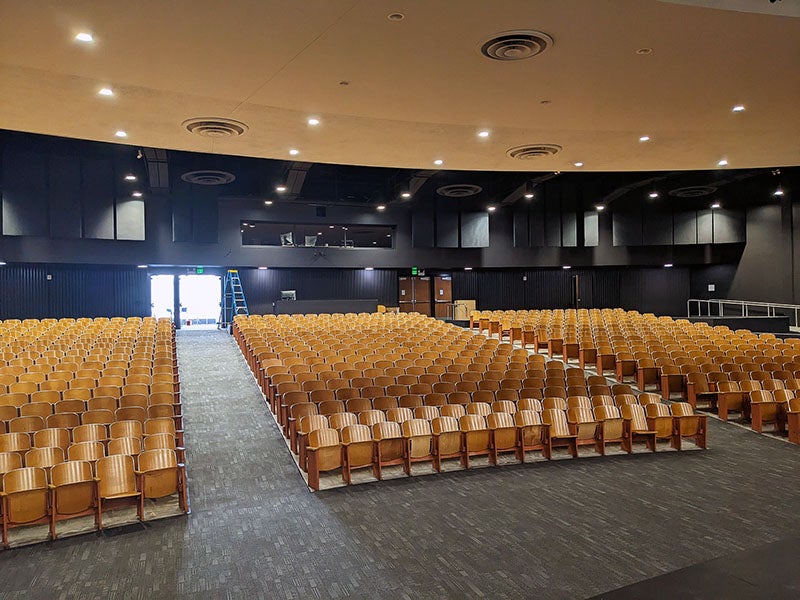 an auditorium view from the front with tiered rows of theater seats 