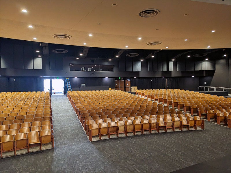 an auditorium view from the front with tiered rows of theater seats