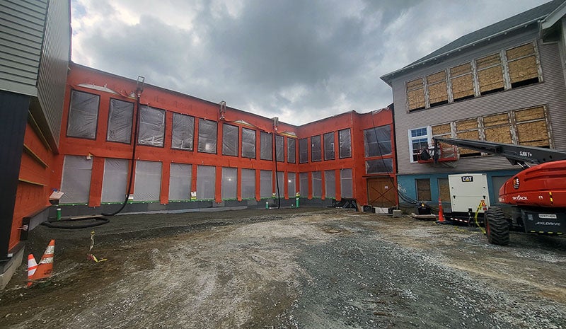 an unfinished courtyard area surrounded on three sides by a building under construction