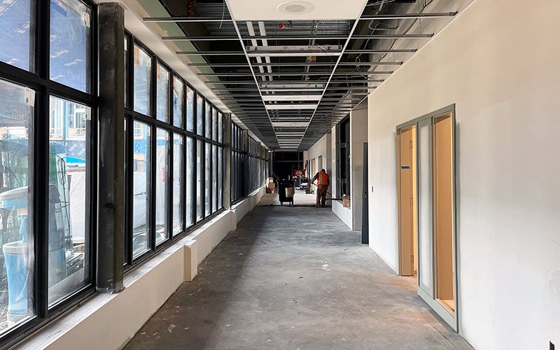 a long hallway with windows on one side and doors on the other side