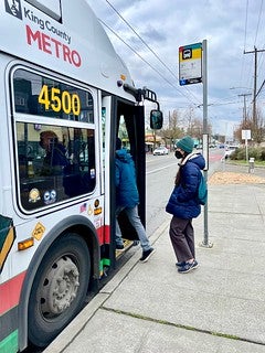Two people getting on the Metro Bus Route 7.