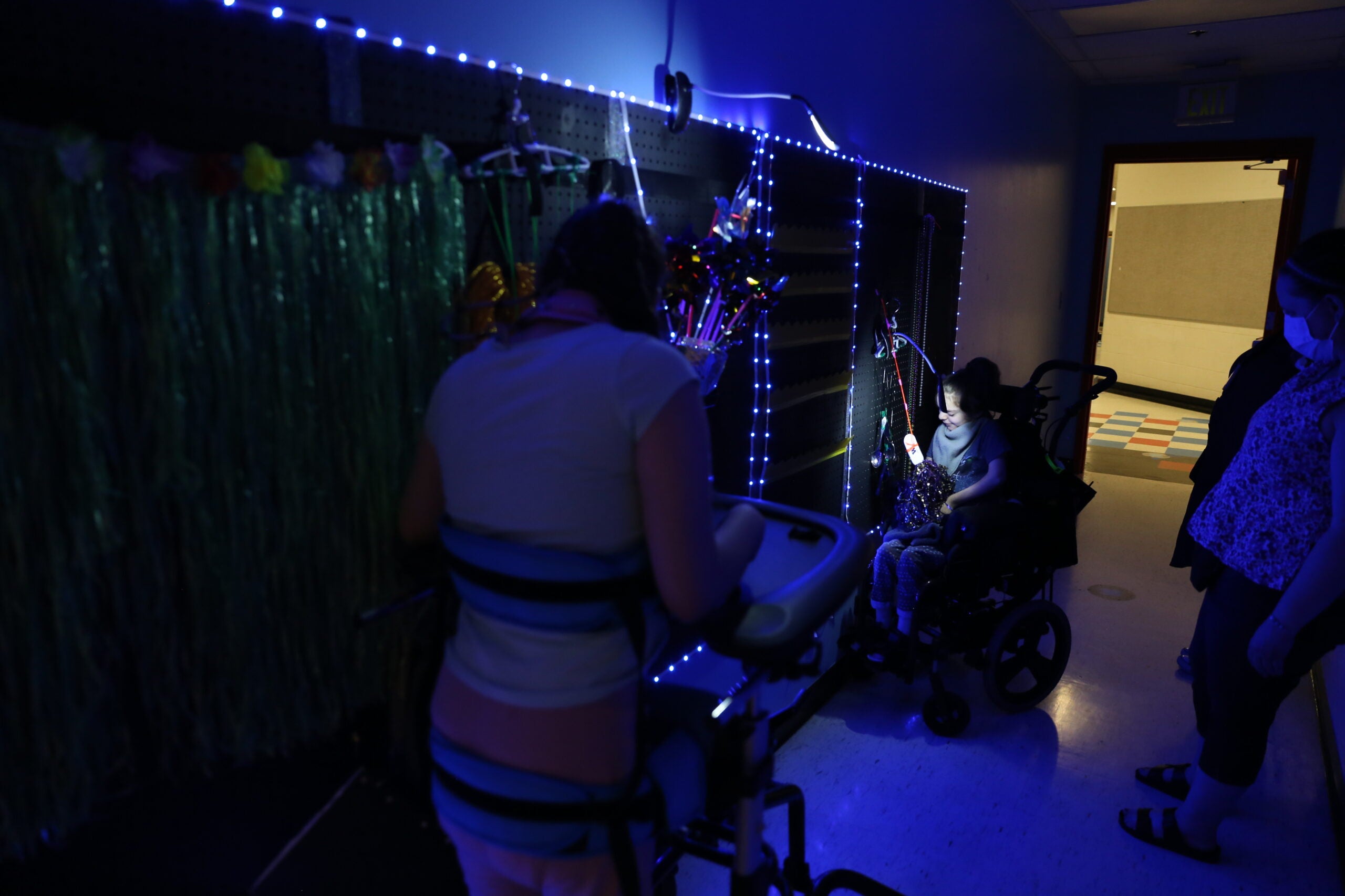 Student play in front of blue lighted sensory wall.