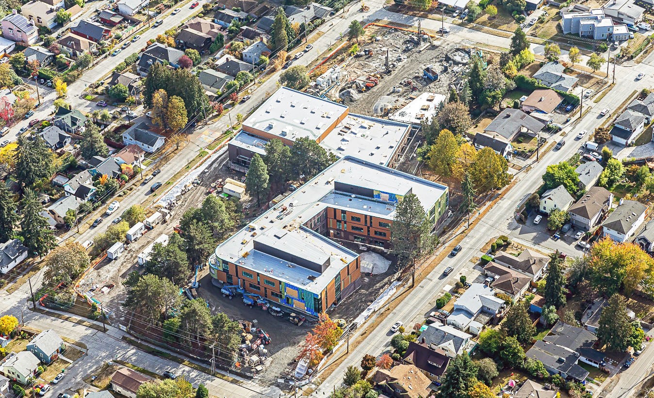 aerial photo of two large connected buildings with outdoor construction work happening