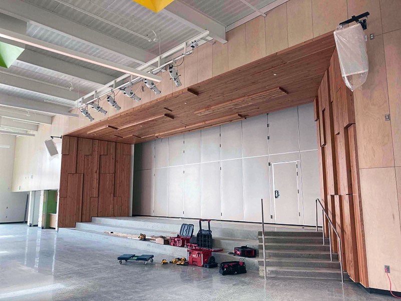 Proscenium surrounding a stage is made of wood. the stage and steps leading to it are concrete