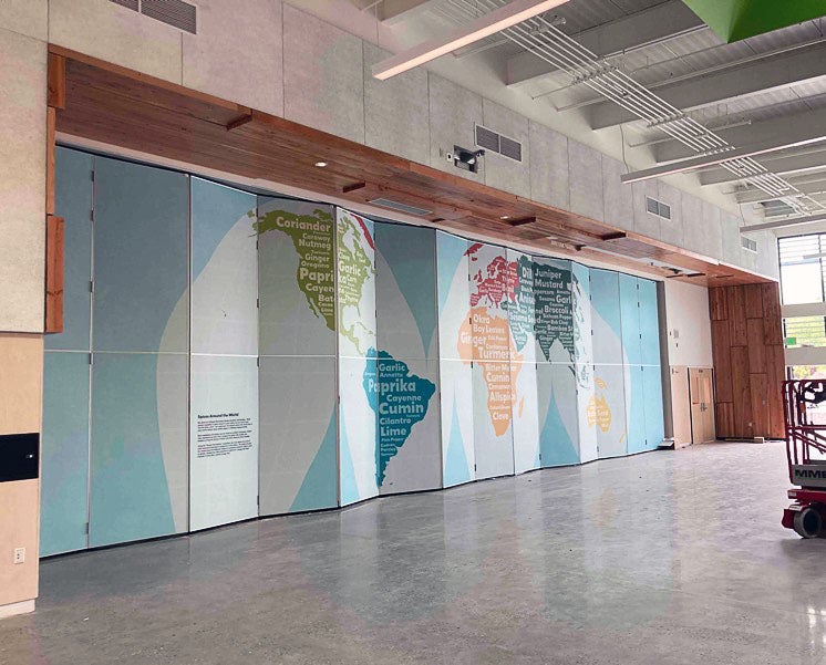 a wall has a indent that contains a very large section of folding wall covered with a map image
