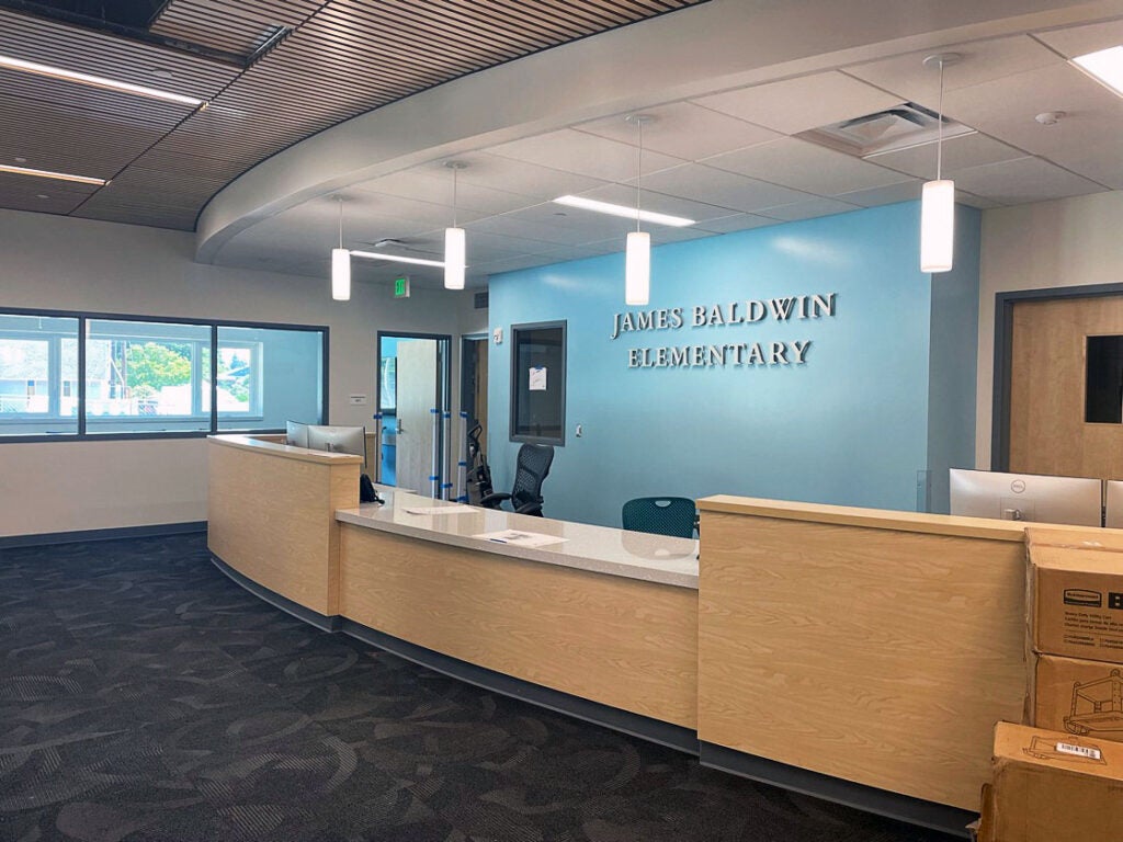 interior space with a reception desk. wall behind says James Baldwin Elementary