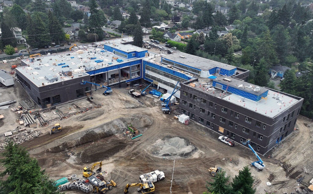 aerial photo showing various construction work on a large L shaped building