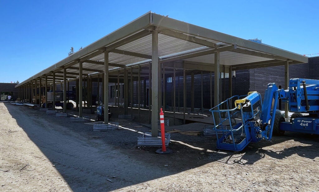 a breezeway with metal posts is in front of a building