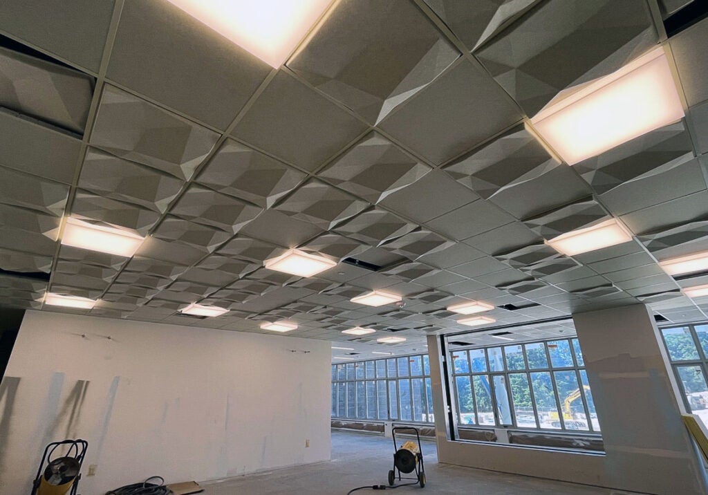 looking up to a ceiling with lights and dimensional ceiling tiles in a grid