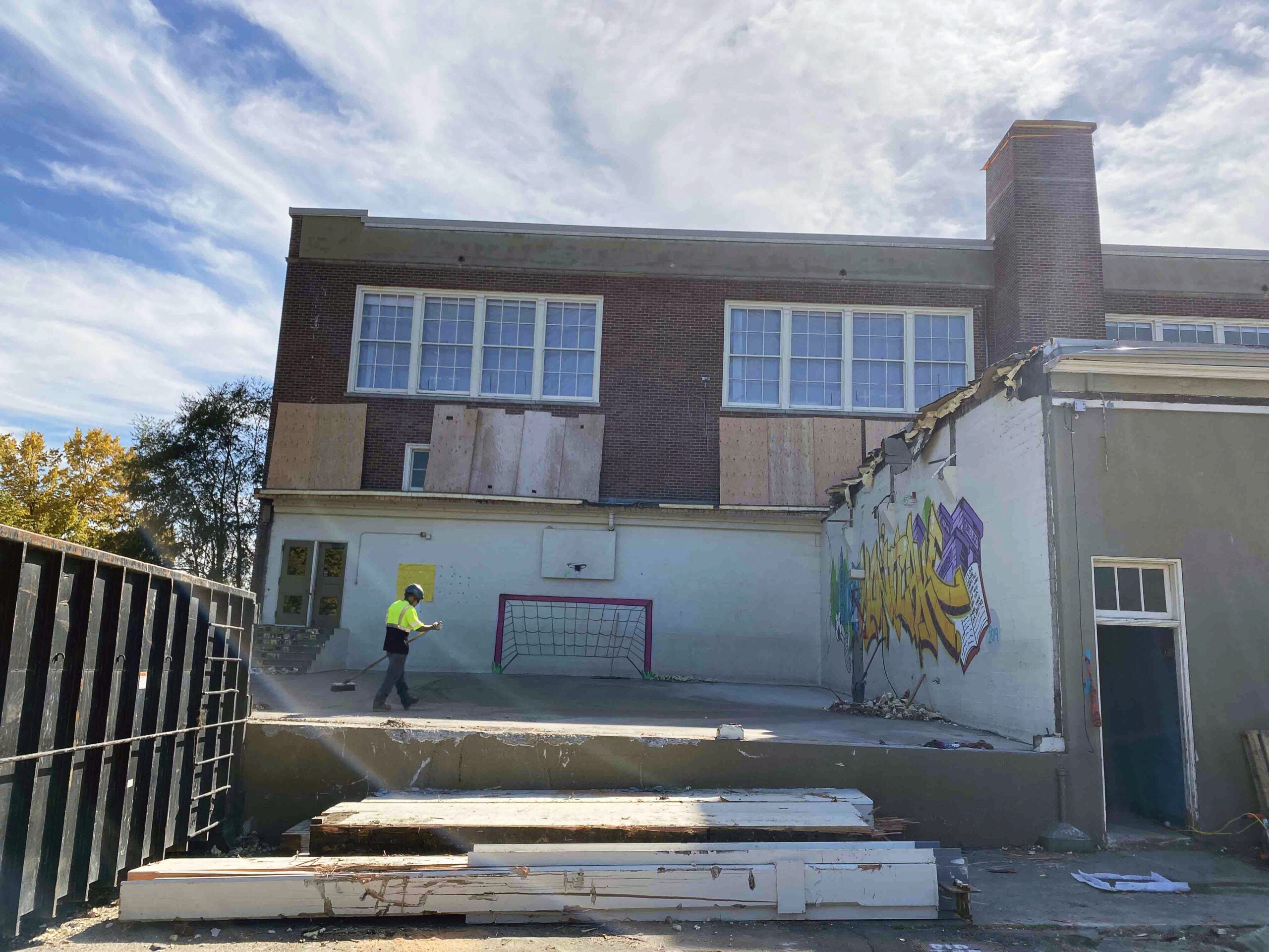 a two story brick building has had something removed over a concrete pad