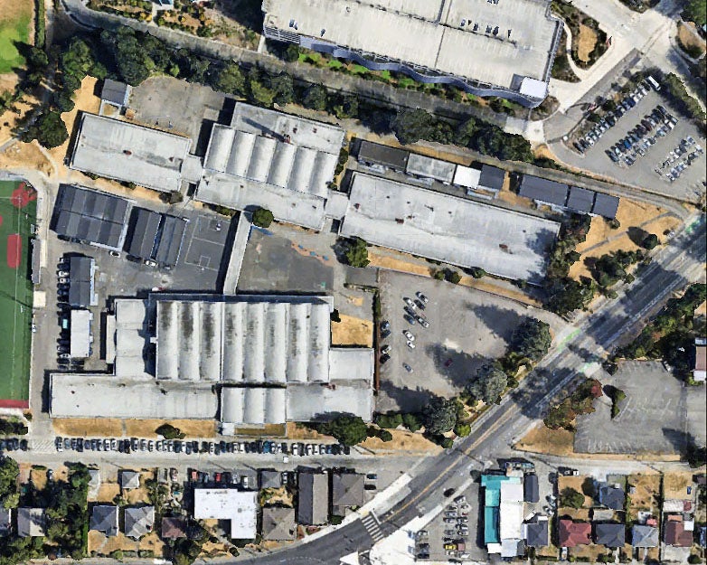 aerial view of a group of large buildings with concrete grounds