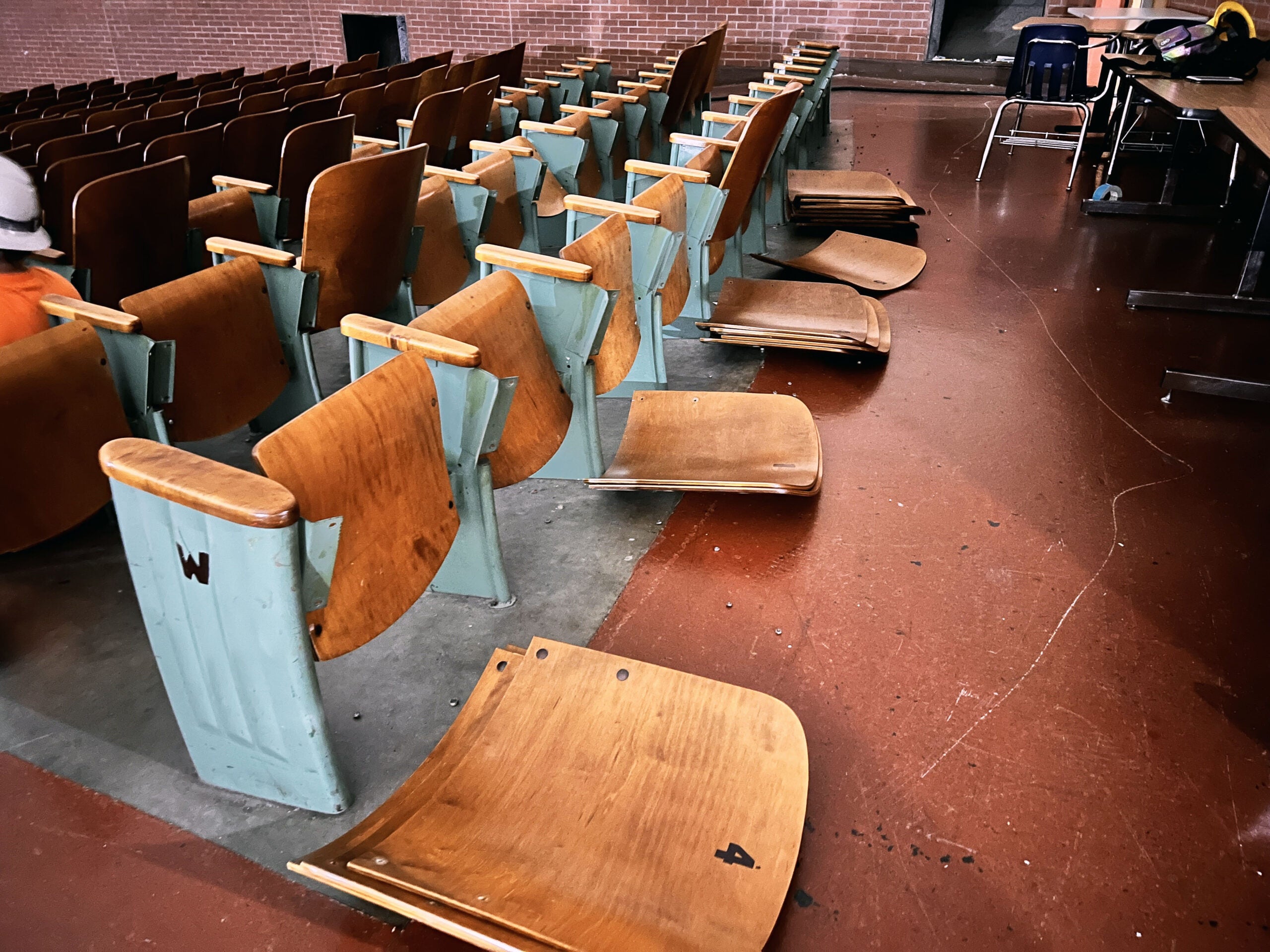 theater seats in a row have the backs removed and lying on the floor