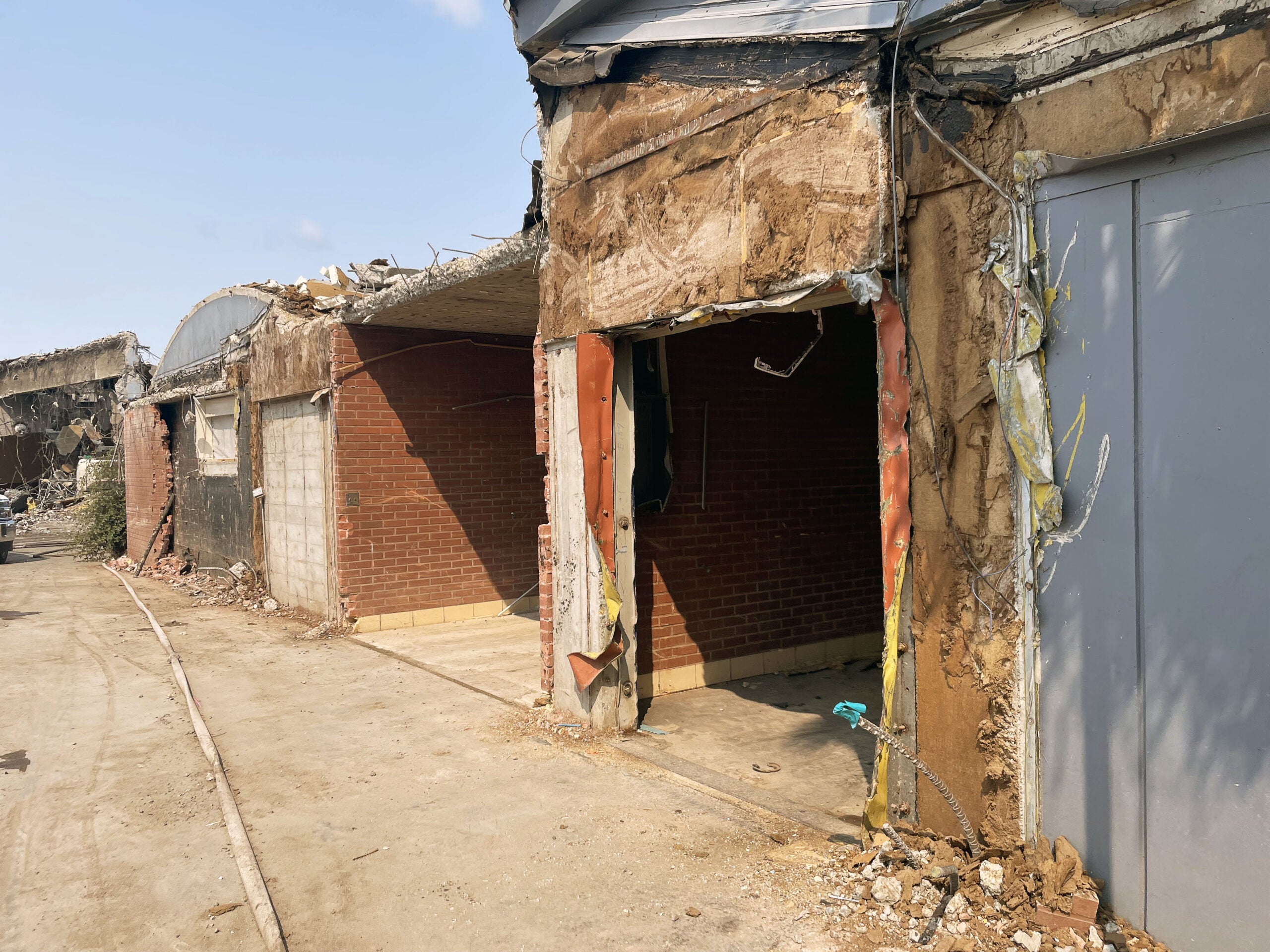 a partially demolished building that is part brick. the brick part remains