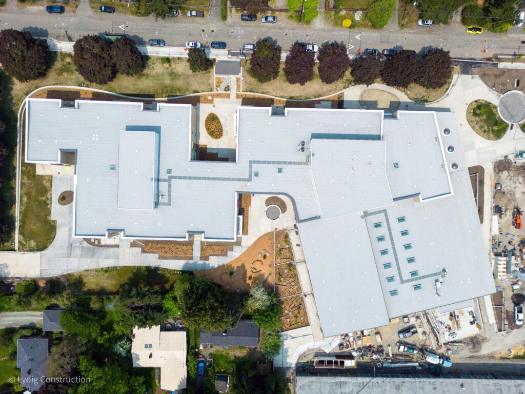 aerial photo of a large building with a road at the top and trees along the road