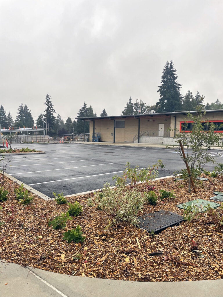 a parking lot next to a one story building with an orange window frame