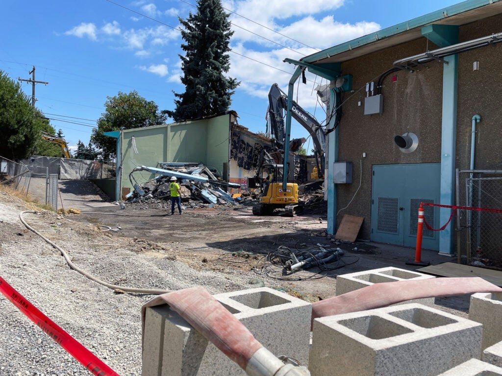 an excavator is demolishing a building