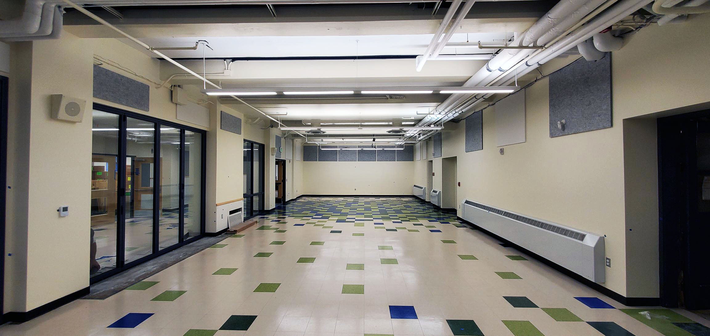 a large empty room has large folding glass doors on one side